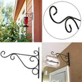 Wall Mounted Flower Pot Hanger Stand by Metallics Home features a decorative black metal design for hanging pots or signs.