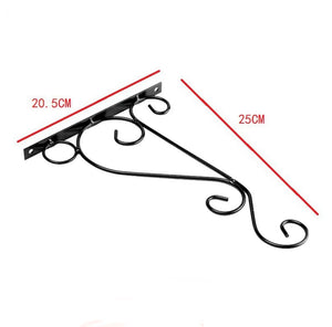 Wall Mounted Flower Pot Hanger Stand by Metallics Home features a black metal design with decorative scrolls, measuring 20.5c