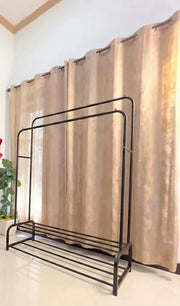 Dual Pole Metal Clothes Stand by Metallics Home featuring dual shoe tiers, set against a backdrop of curtains.