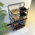 Foldable Metal Shoes Rack by Metallics Home displaying multiple pairs of shoes on a sleek black frame, set against a light ba