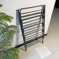Foldable Metal Shoes Rack by Metallics Home, featuring a sleek black design, stacked against a wall for space-saving storage.