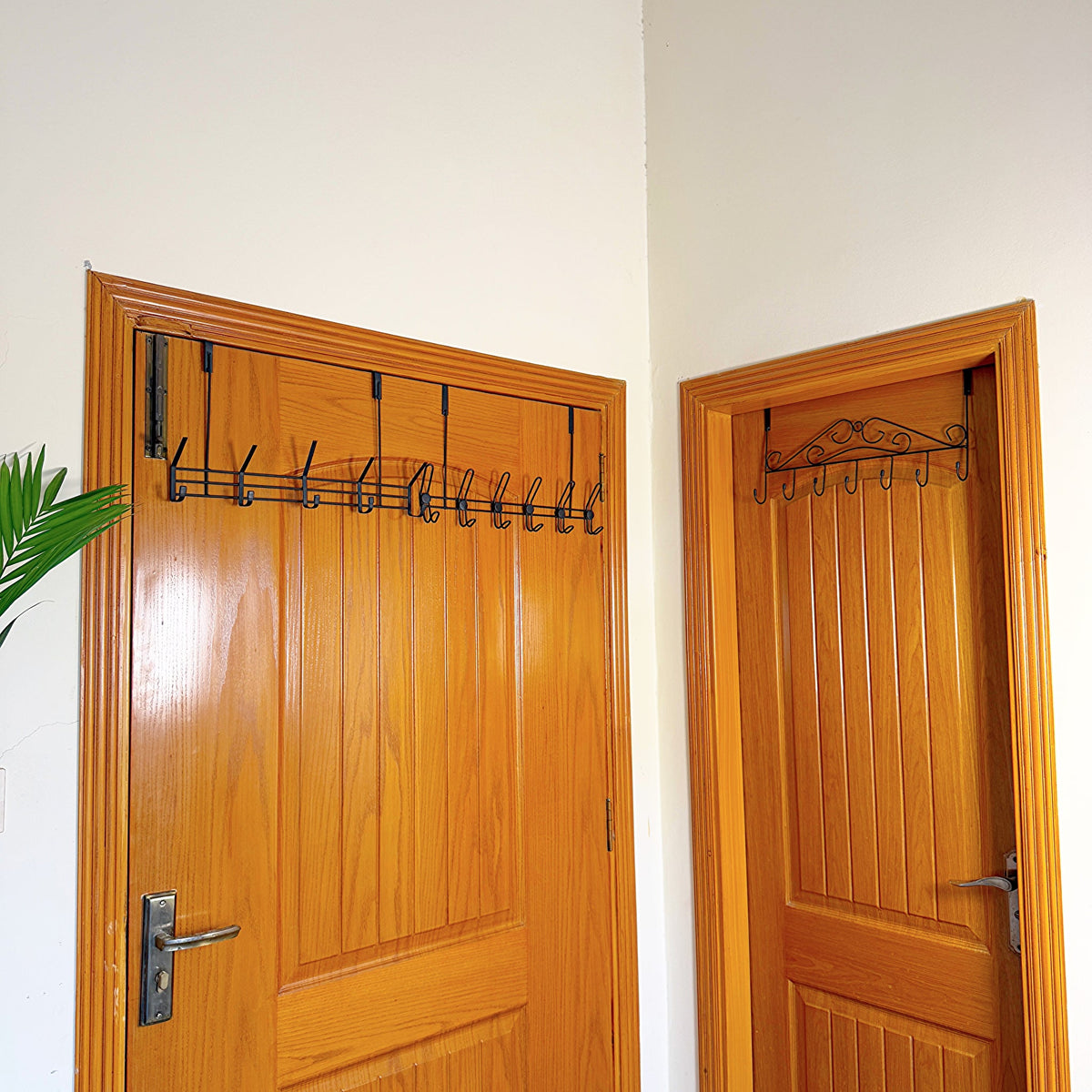 Set of 3 Over the Door Hangers by Metallics Home, featuring black metal hooks mounted on wooden doors for storage.