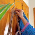 Set of 3 Over the Door Hangers by Metallics Home, featuring a hand hanging a bag on a stylish black metal hook.