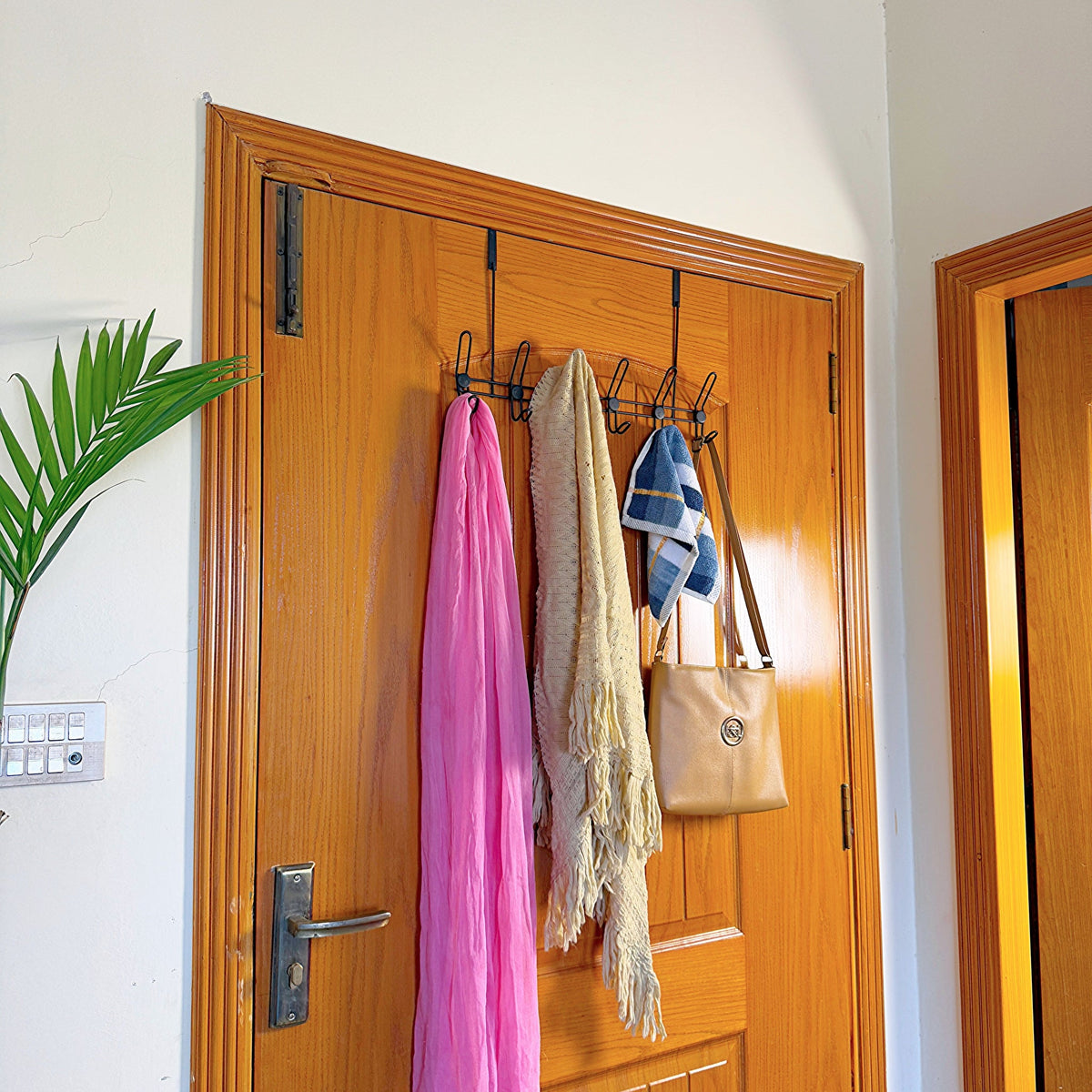 Set of 3 Over the Door Hangers by Metallics Home, featuring scarves and a handbag hanging on a wooden door.