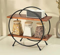 Orbit Duo Shelf by Metallics Home features a circular black metal frame with two wooden shelves, holding four glass jars.