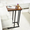 Wooden C Table and Side Table by Metallics Home featuring a sleek wooden top and black metal frame, placed beside a sofa.