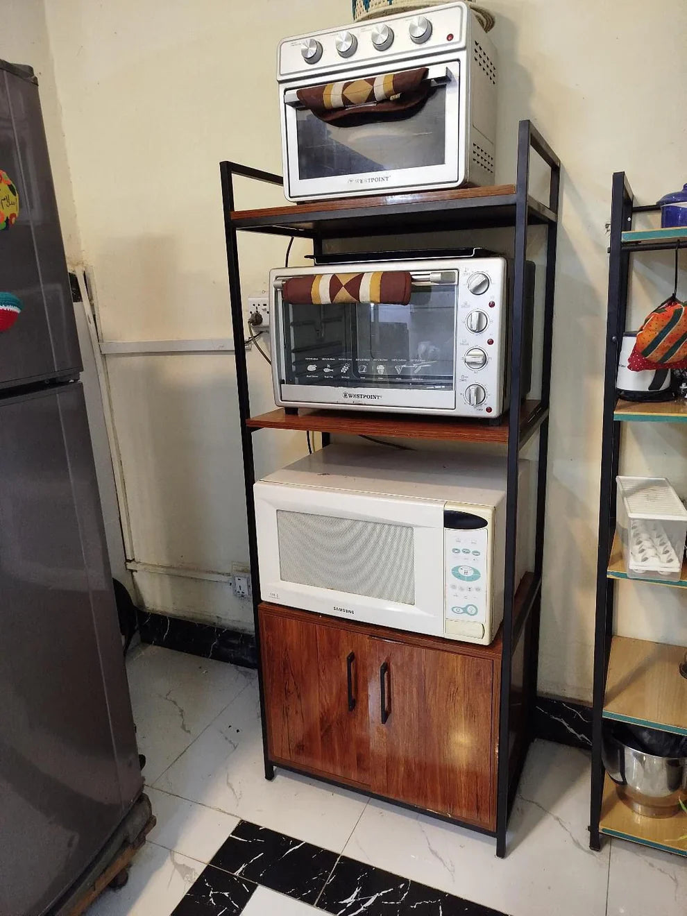 Maxistack multipurpose storage rack with cabinets featuring three shelves for appliances and a wooden cabinet at the bottom.