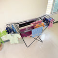 Premium Metal Folding Cloth Dryer Stand by Metallics Home with clothes hanging on it, set against a light-colored wall.